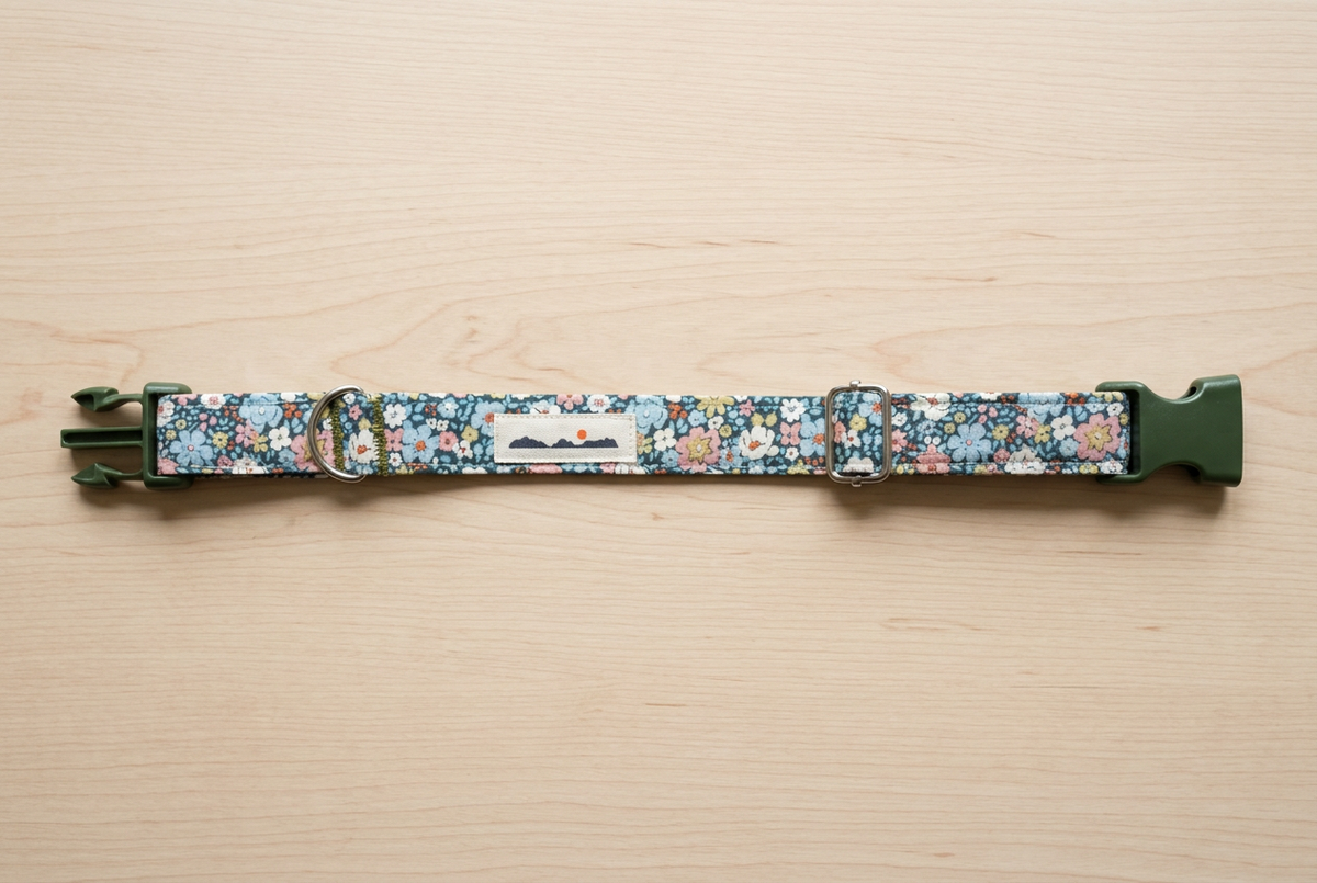 Collar floral con cierre verde oscuro sobre madera clara